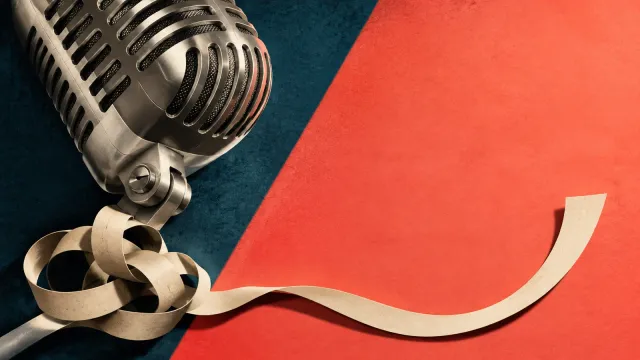 A silver microphone and curling blank paper ribbon against teal and coral paper.