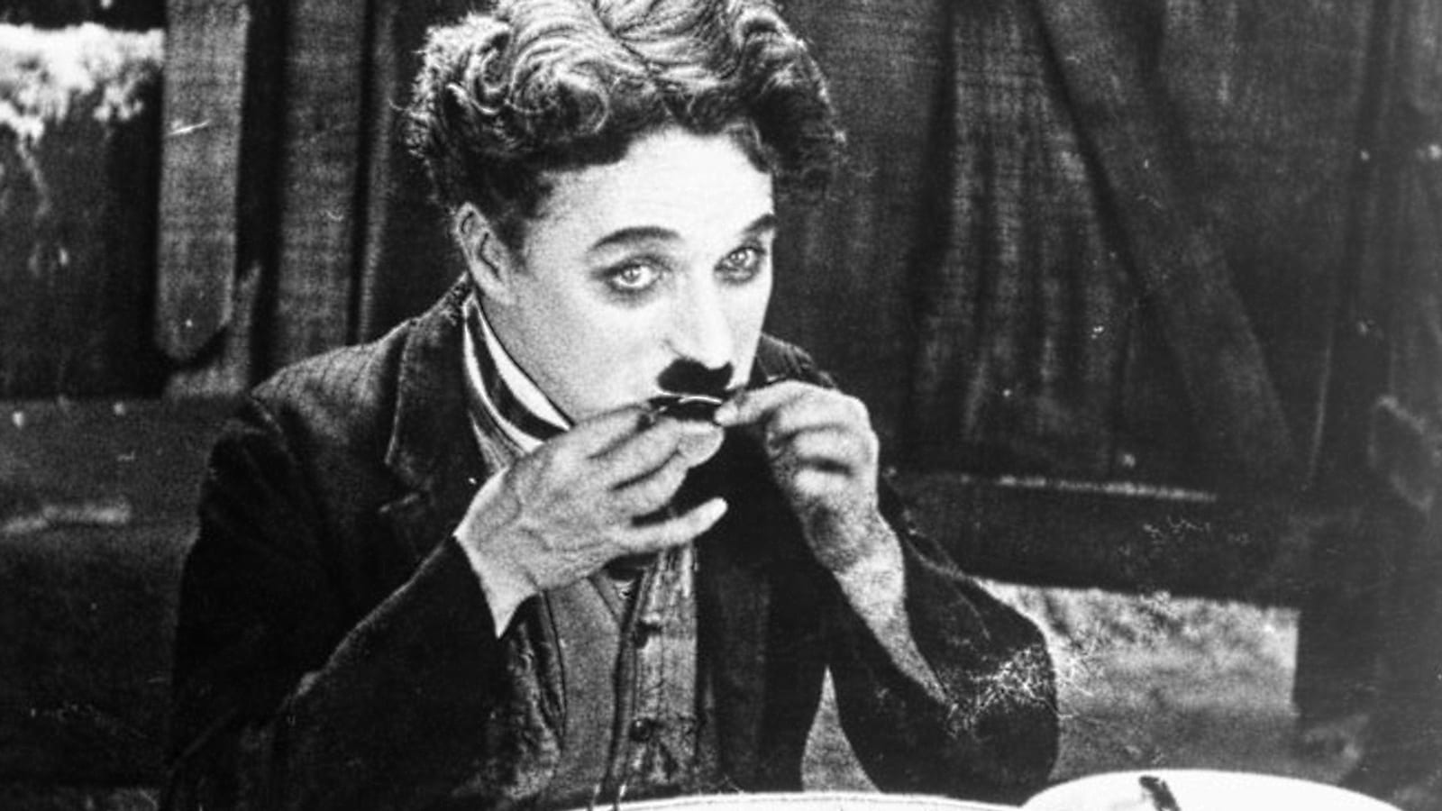 Charlie Chaplin eating a boot in a publicity still for The Gold Rush